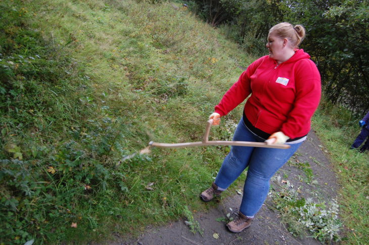 Volunteer from People's Postcode Lottery scything the meadow at Jupiter Urban Wildlife Centre © Rory Syme