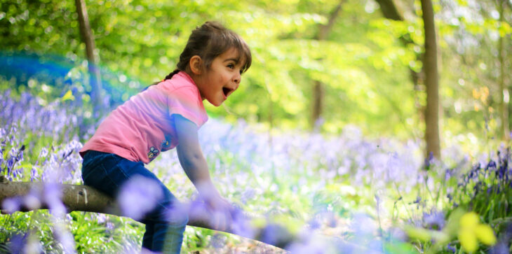 Girl playing in the bluebells