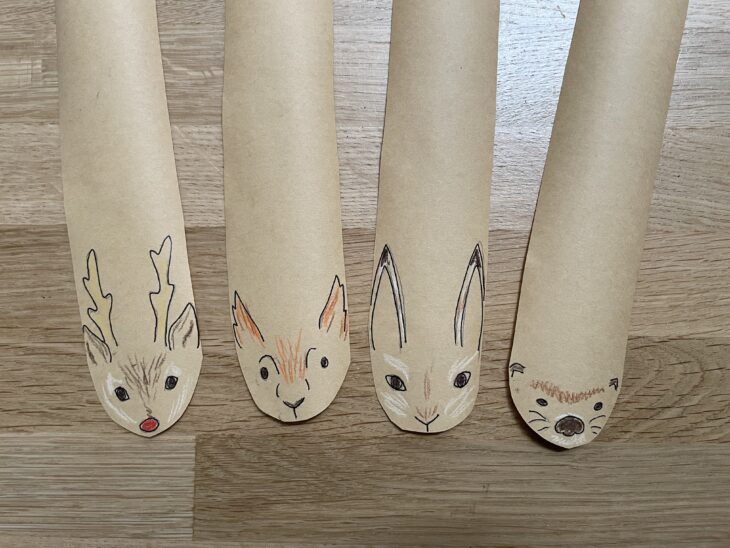 four strips of brown paper with the face of a reindeer, red squirrel, hare, and otter on the end.