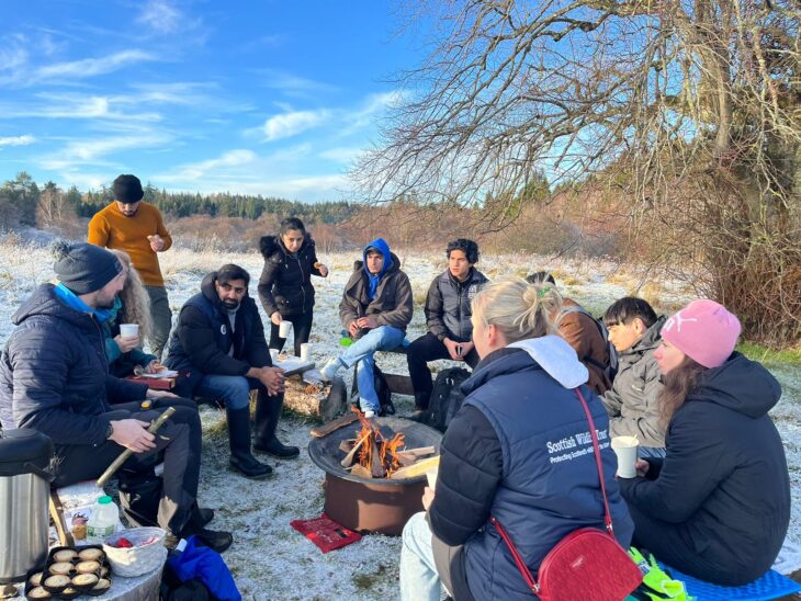 Refugees and asylum seekers taking part in badger crafts at Falls of Clyde.