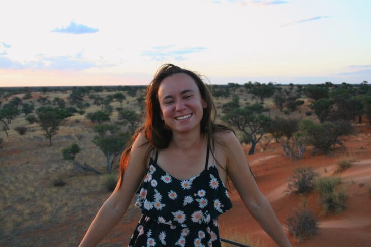 Scottish Wildlife Trust volunteer Annelise van Eeden is standing in a sandy landscape with small trees growing in the background.