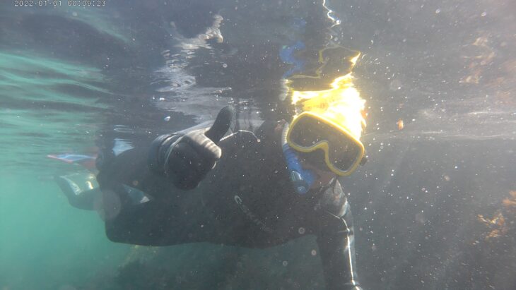 A snorkeller gives a thumbs up for the camera.