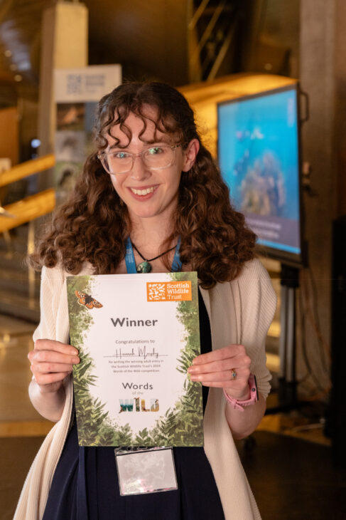 Words of the Wild winner, Hannah Murphy, holding her certificate