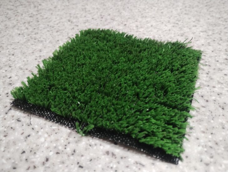 A small square of artificial grass on a table.