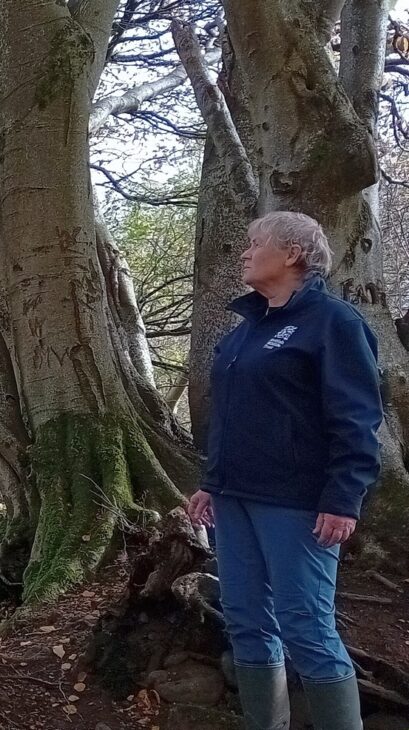 Action for Nature volunteer, Wendy Wilson, standing in a forest.